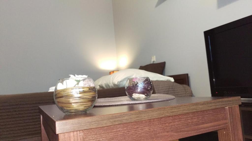 una mesa con dos jarrones en ella con una cama en Apartament Styl, en Szczecin