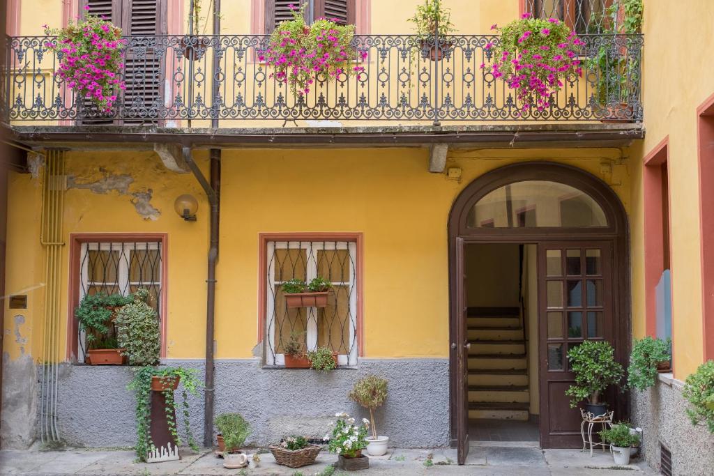 uma casa amarela com uma varanda e uma porta em ViaBasso11 Guest House em Novi Ligure