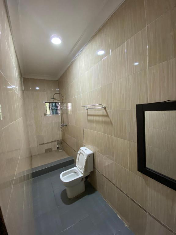 a bathroom with a white toilet in a room at MerryJay Hotels in Otta