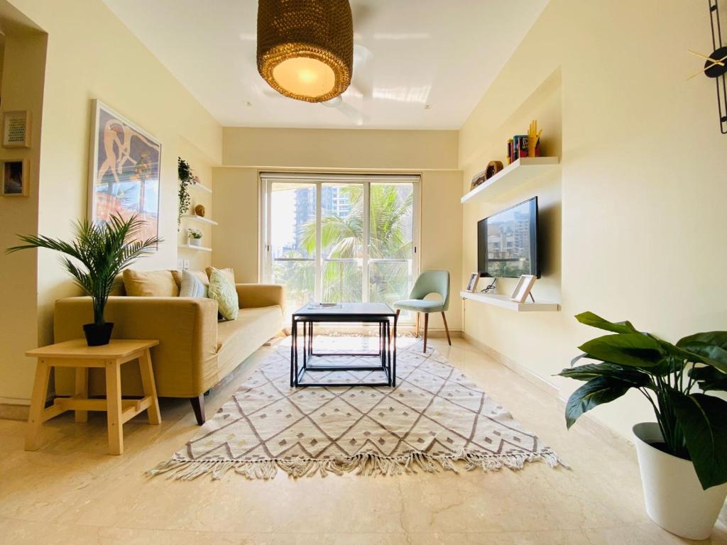 a living room with a couch and a table at ConnektHomes - Modern2Bed-BandraArea in Mumbai
