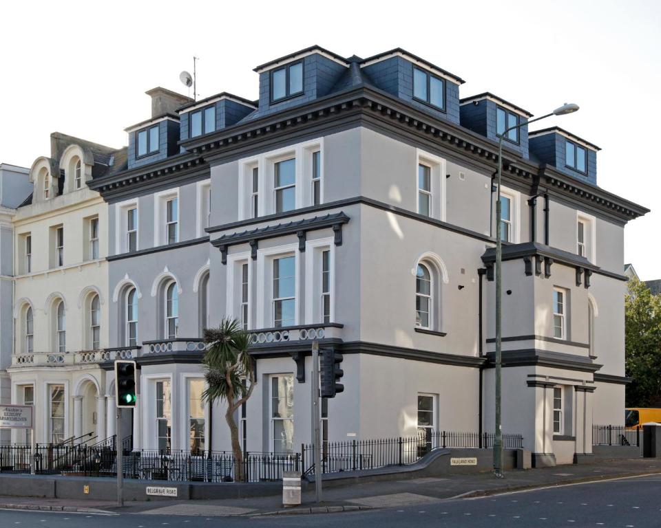 a white building on the corner of a street at Austens Apartments in Torquay