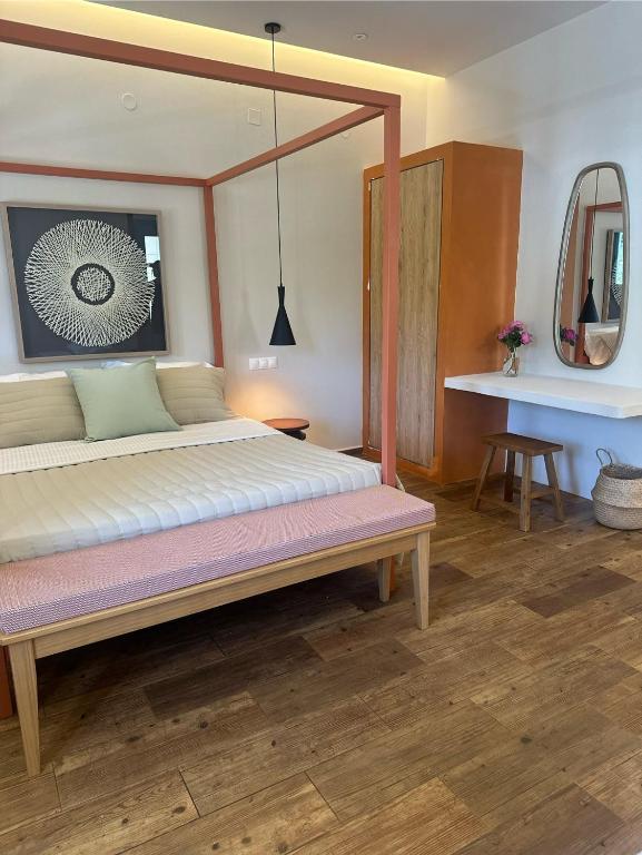 a bedroom with a bed and a mirror and a table at Apocalypsis Houses in Skala