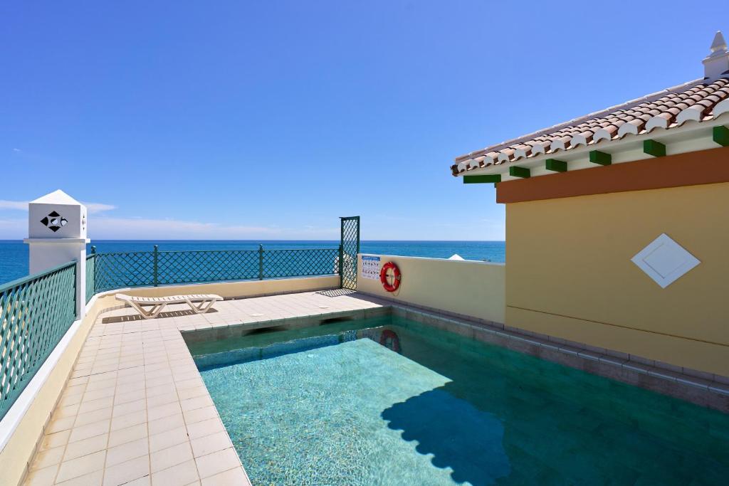 a swimming pool on the balcony of a house with the ocean at Club Oasis Flat in Málaga
