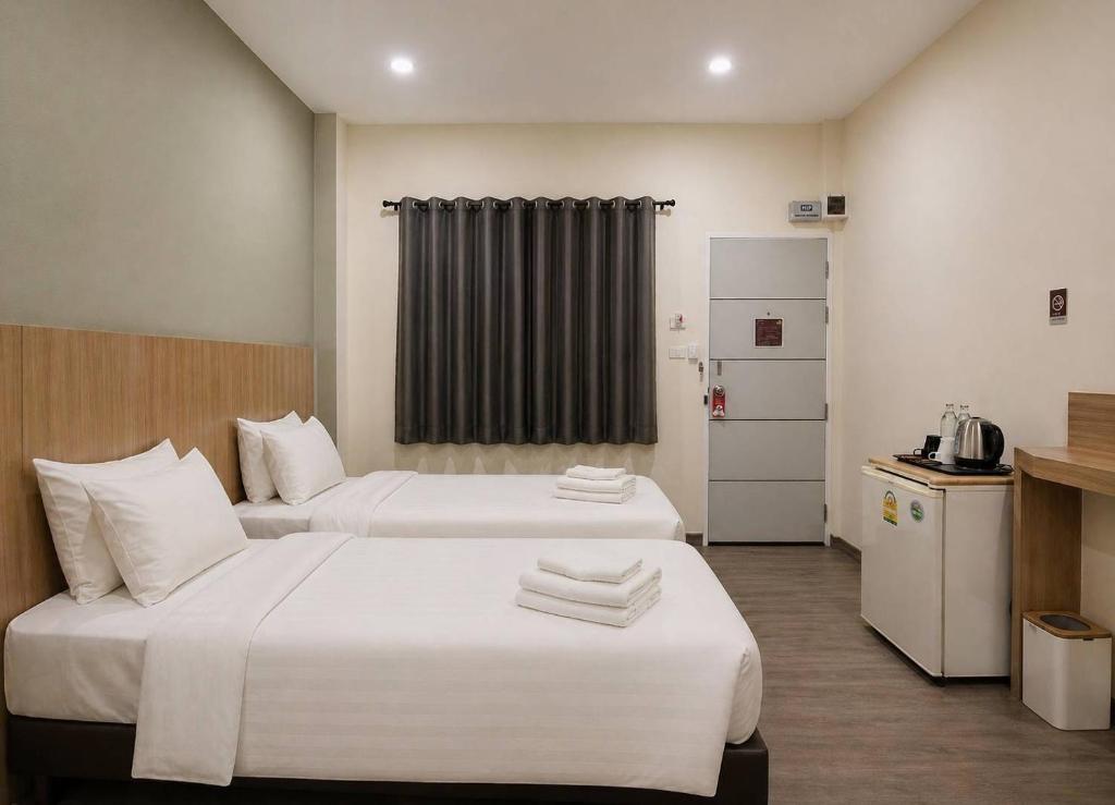 a hotel room with two beds and a kitchen at Beyond 21 Hotel in Khon Kaen