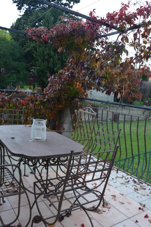 a table and chairs in a garden with a fence at Fabetmie in Mormoiron