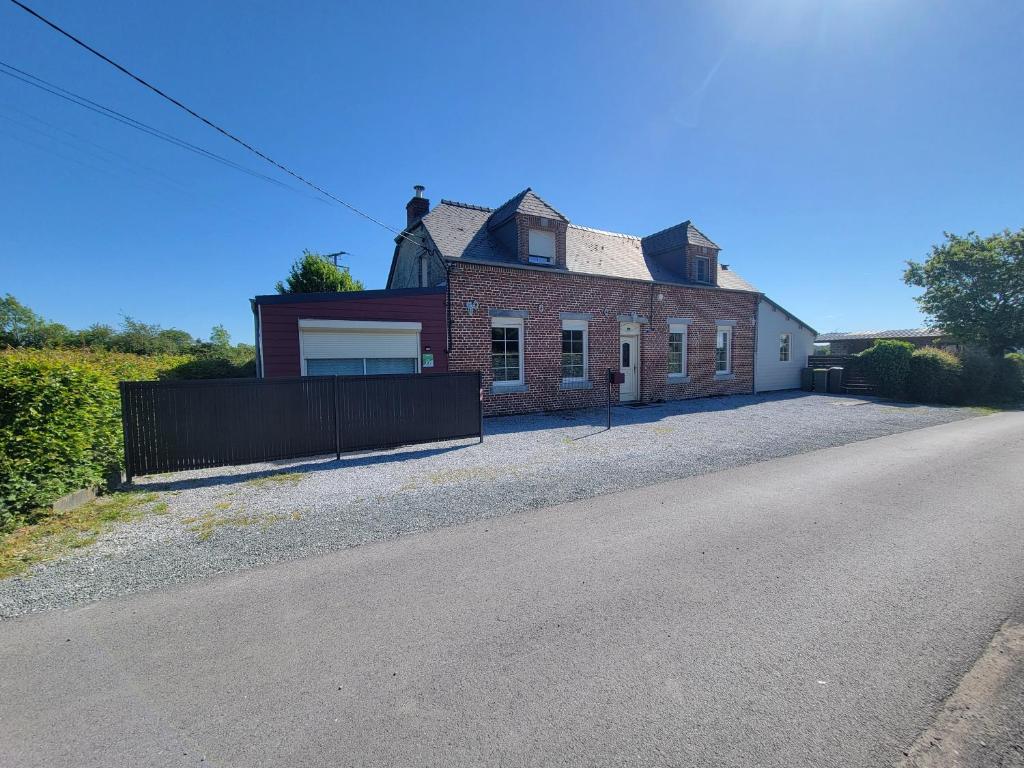 a large brick house with a garage on a street at Les Gîtes de la chapelle blanche in Anor