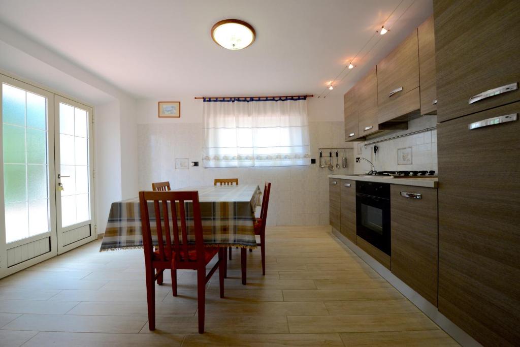 a kitchen with a table and chairs and a kitchen with a window at Appartamento Pietri in Marina di Campo