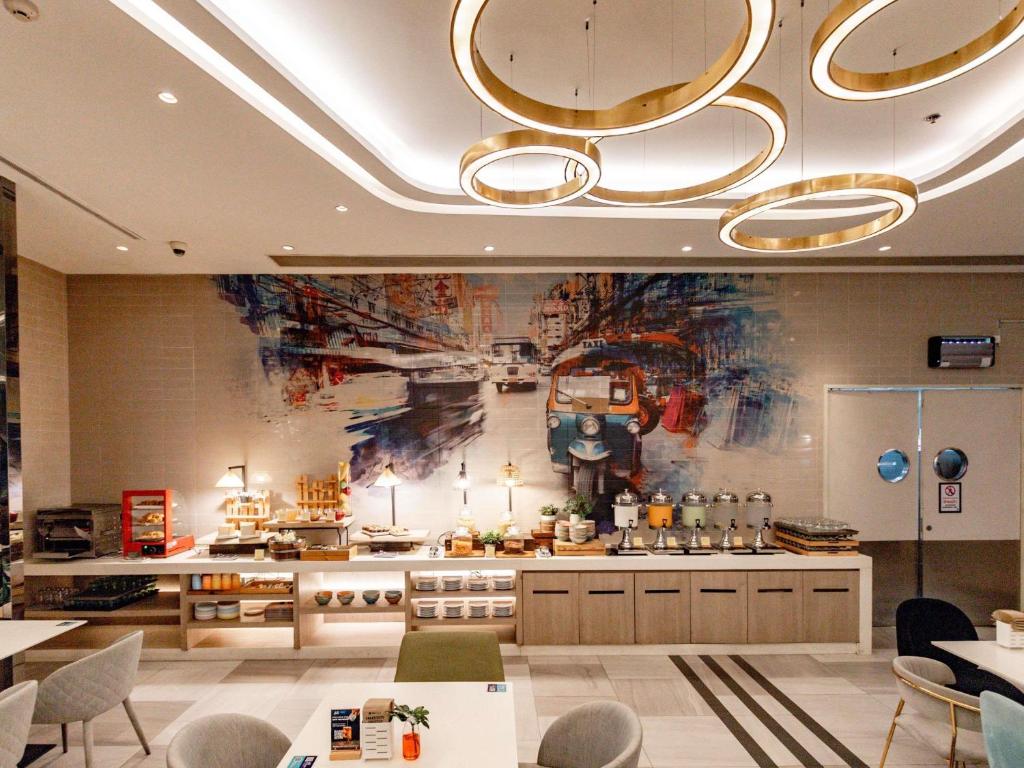 A wide view of the buffet and dining area, framed by circular ceiling lights and a large tuk-tuk mural.