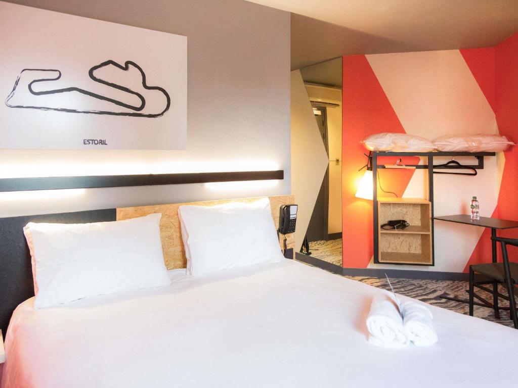 a bedroom with a bed with white sheets and white pillows at ibis Styles Bâle-Mulhouse Aéroport in Blotzheim