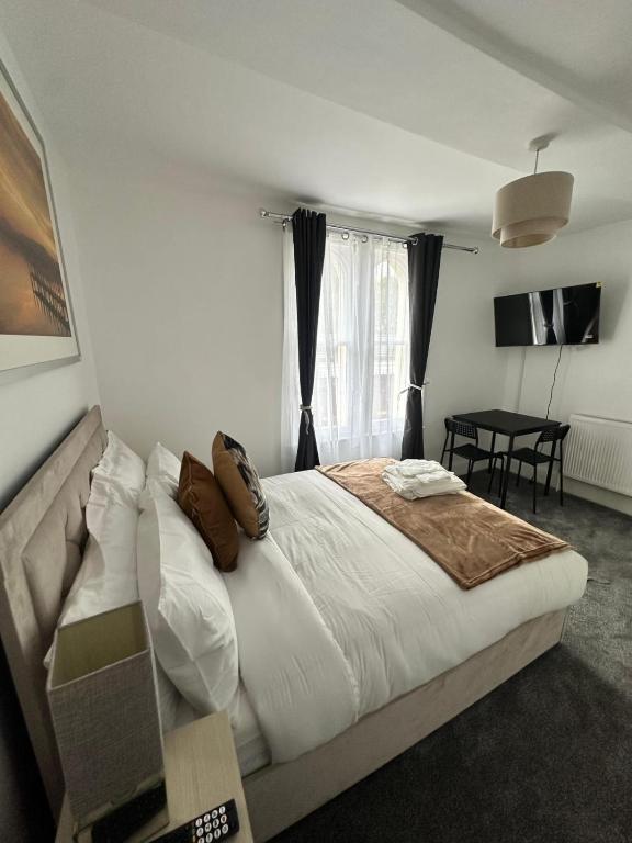 a bedroom with a large bed and a table at Glams luxury home in Wolverhampton