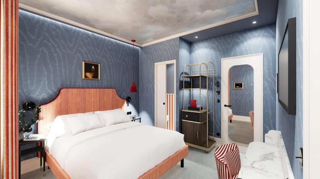 a bedroom with a white bed and a blue wall at Grand Hôtel De Turin in Paris