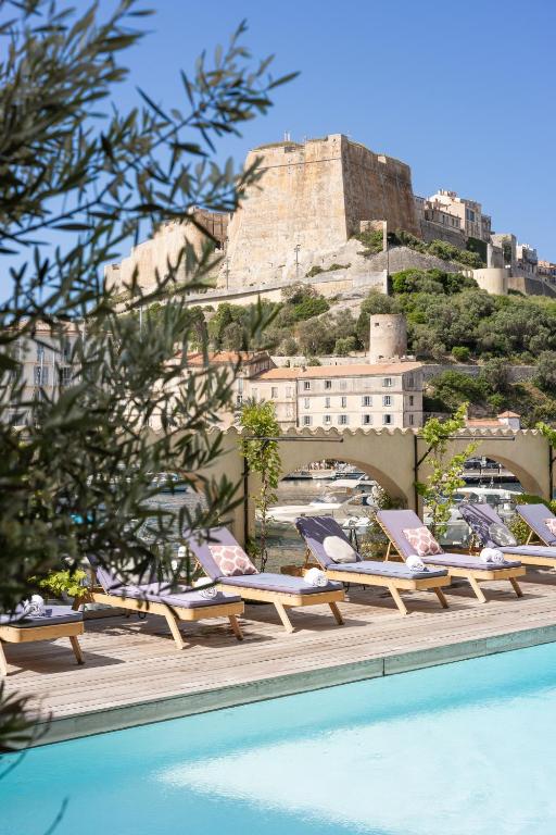 a row of lounge chairs next to a swimming pool at Solemare in Bonifacio