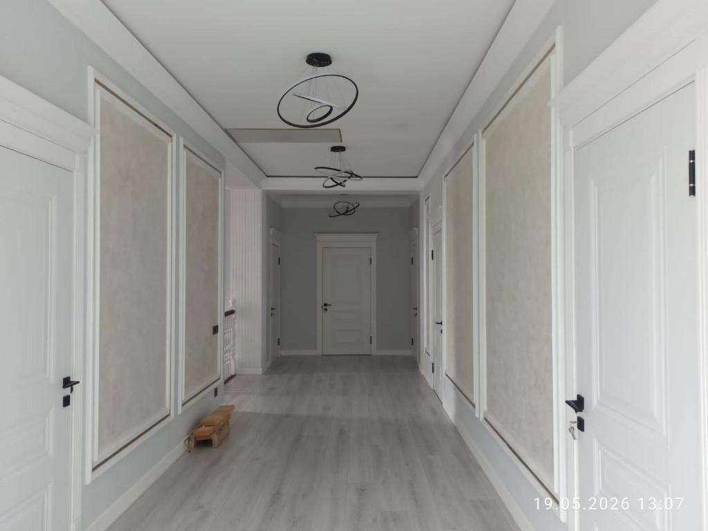 an empty hallway with white walls and a ceiling at Village House in Zhabagly