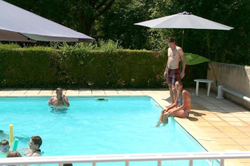 a group of people sitting in a swimming pool at Camping 3 étoiles - Piscine - ccbgbeh in Puy-lʼÉvêque