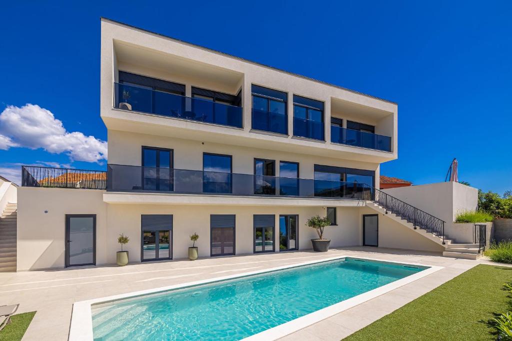 an exterior view of a house with a swimming pool at Luxury apartment LaRiv II with pool in Krk