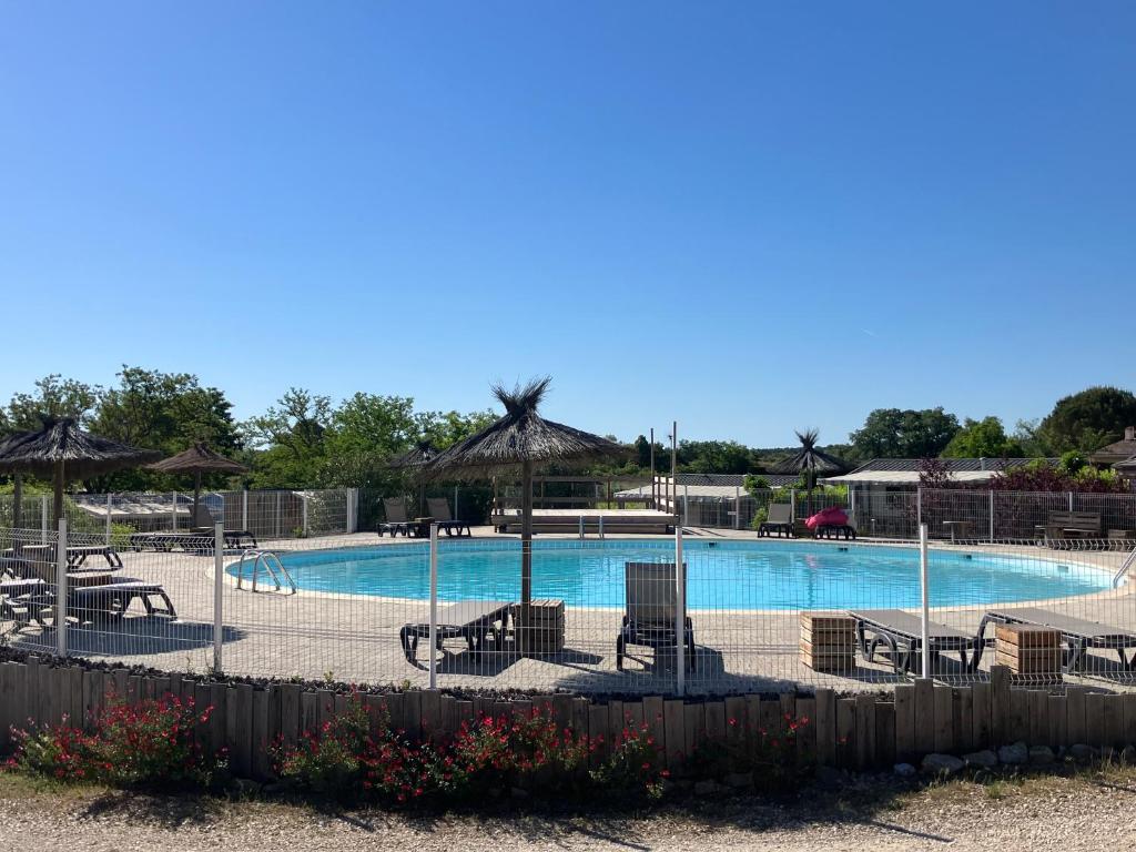 a swimming pool with chairs and umbrellas at Camping familial 3 Etoiles avec piscine Carrefour de l'Ardèche in Saint-Remèze