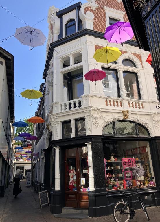 a building with colorful umbrellas hanging from it at Gilded Ox Suites in Deventer
