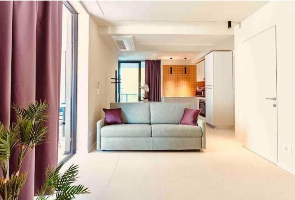 a living room with a couch and a kitchen at Aparthotel Zefiro com design, large terrace, bike, near beach and thermal in Grado