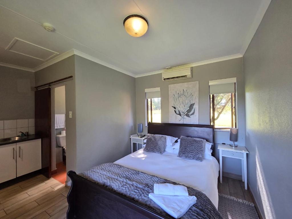 a bedroom with a bed and two tables and a mirror at Azalea at Greenway Woods in White River