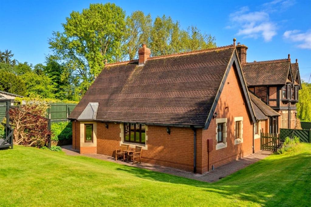 a small brick house with a grass yard at Finest Retreats - The Grove Annexe in Craven Arms