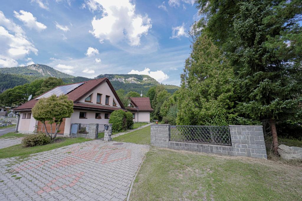 a house with a fence in front of a yard at Apartman Nina in Kvačany