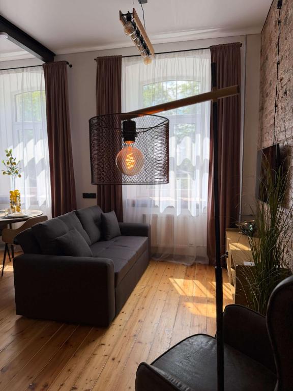 a living room with a couch in front of a window at Urban Loft Studio 33 in Daugavpils