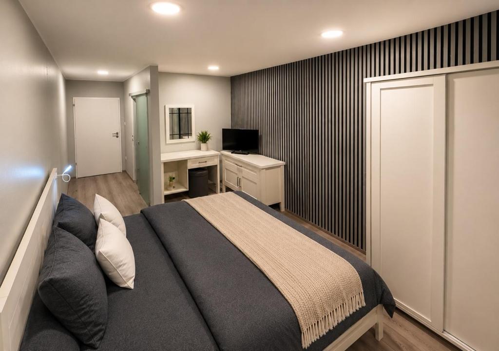 a bedroom with a bed and a desk and a television at ''Am Limes'' Hotel in Enns