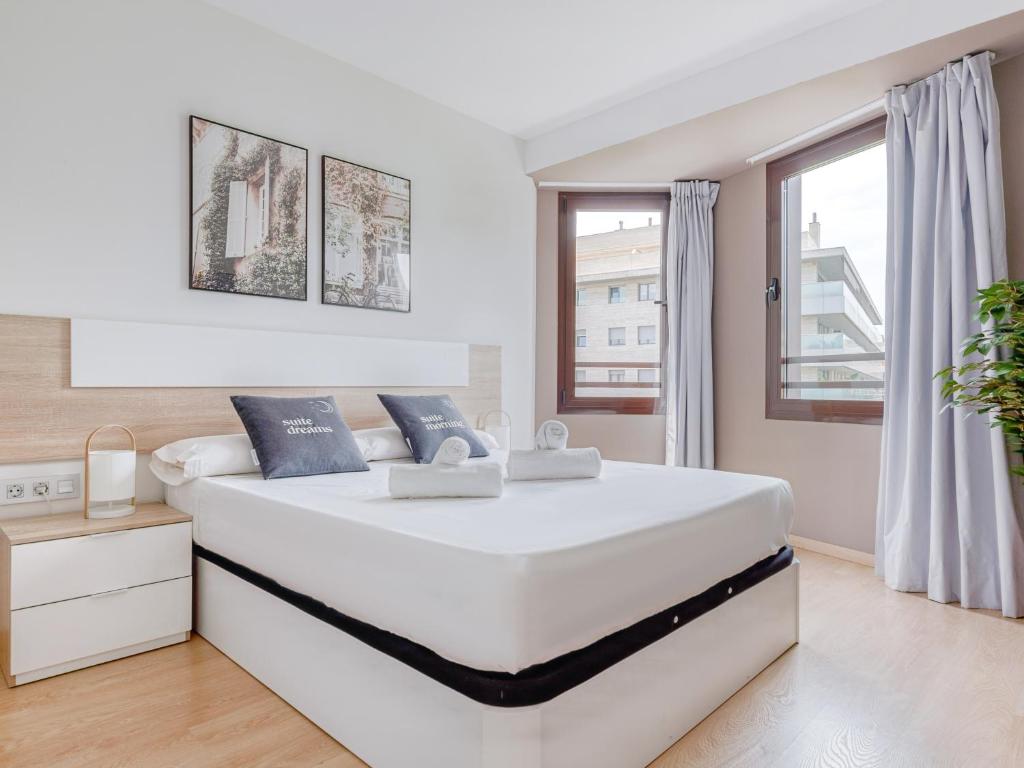 a white bedroom with a large white bed and windows at Limehome Barcelona Carrer de Fontcoberta - Digital Access in Barcelona