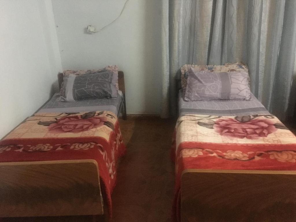 - deux lits assis l'un à côté de l'autre dans une pièce dans l'établissement Sami Hostel, à Jéricho