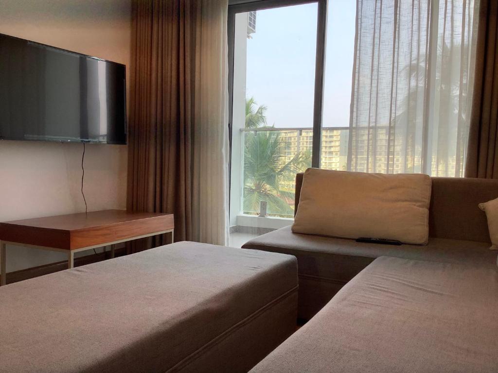 a hotel room with two beds and a large window at Arkad Golf Residence in Gonapola