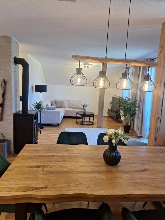 a living room with a wooden table with flowers on it at Appartement Urlaub Exklusiv in Lackenhof