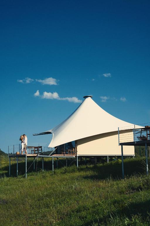 a man standing next to a large white tent at Mili Resort in Polychrono