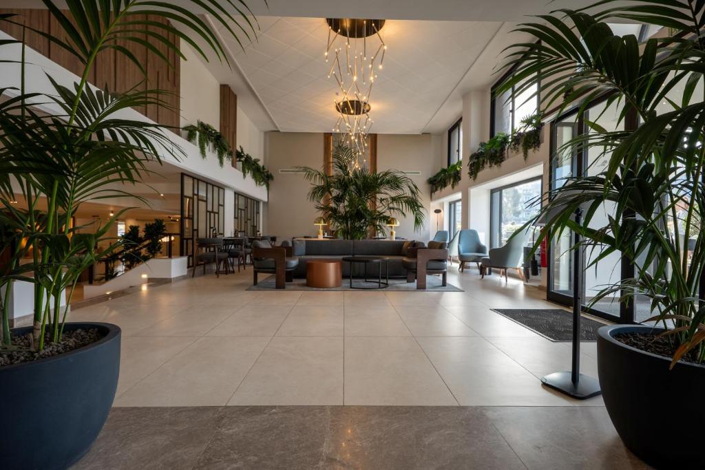 eine Lobby mit Topfpflanzen in einem Gebäude in der Unterkunft Luna Holiday Complex in Mellieħa