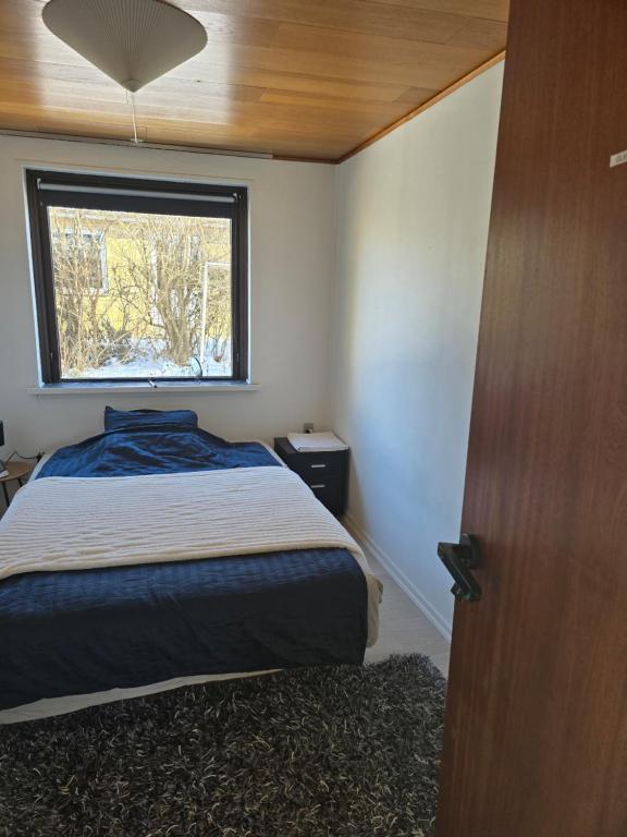 a small bedroom with a bed and a window at Small and cozy room in Kalundborg