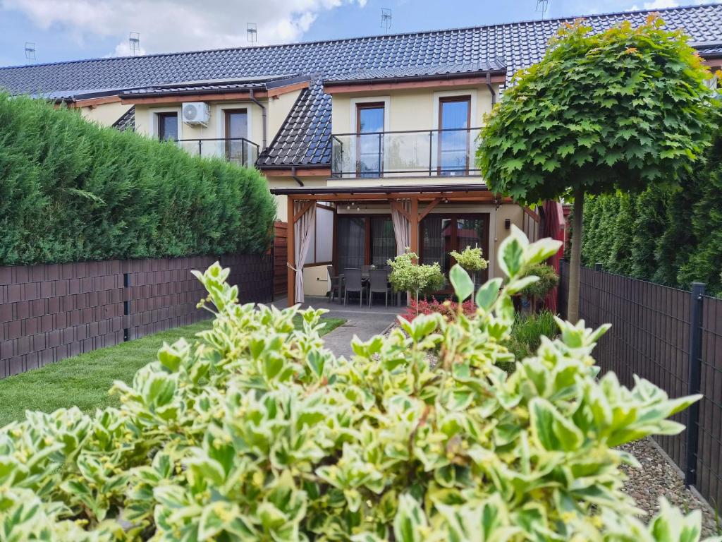 a house with a fence and a yard with bushes at Lawendowa Home in Milicz