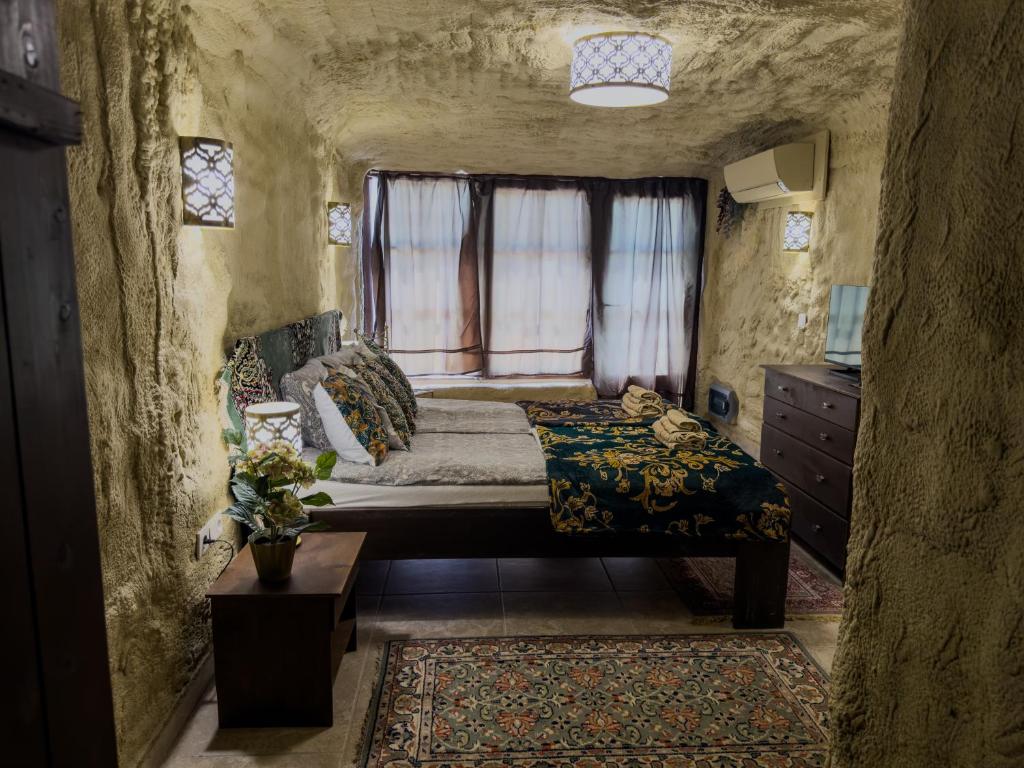 a bedroom with a bed and a window in a cave at Sirocave barlang apartmanok in Sirok