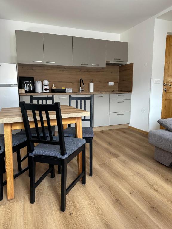 a kitchen with a wooden table and chairs in a room at Apartmaji Anže Kranjska Gora in Kranjska Gora