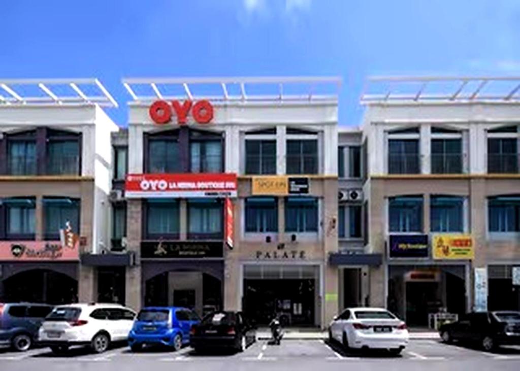 a large building with cars parked in a parking lot at Hotel O Lm Residence in Miri