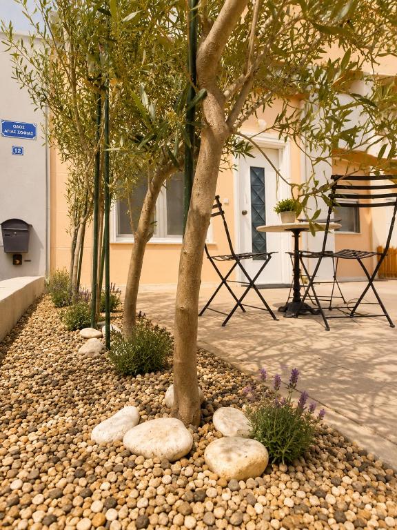 a garden with rocks around a tree and a table at Asana by Agora Flats in Thessaloniki