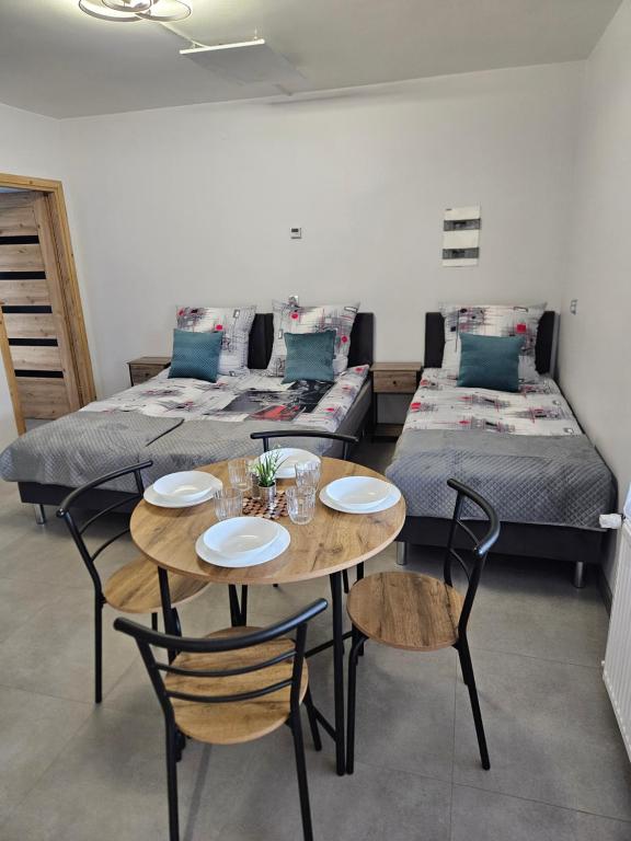ein Zimmer mit zwei Betten, einem Tisch und Stühlen in der Unterkunft Hostel 405 in Polanka Wielka
