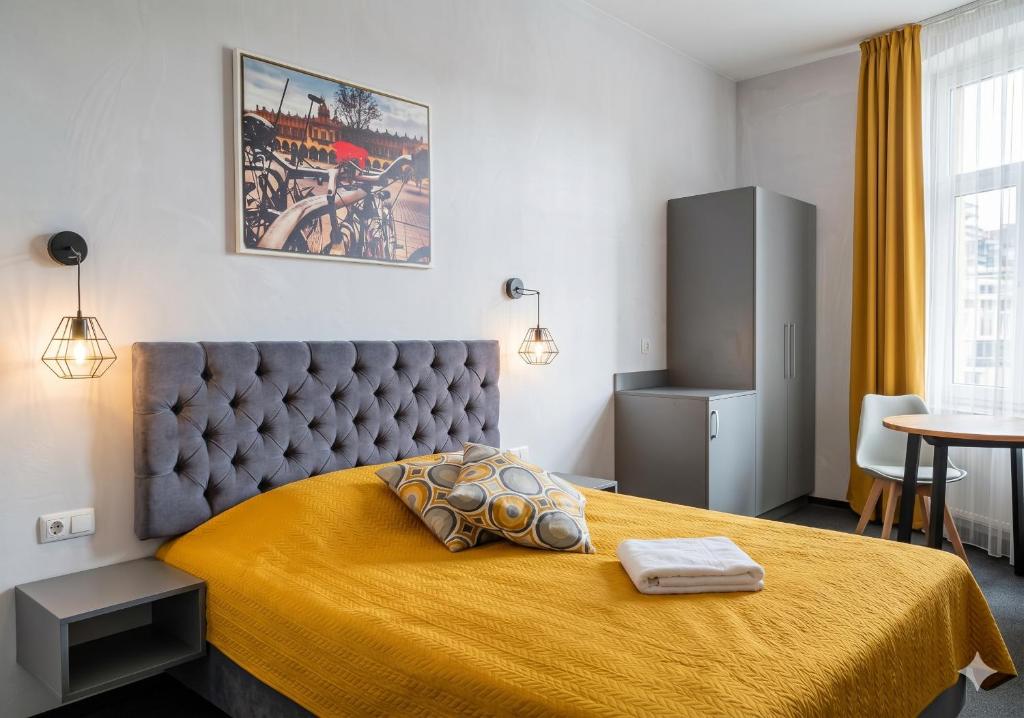 a bedroom with a large bed with a yellow bedspread at Résidence Tournet in Krakow