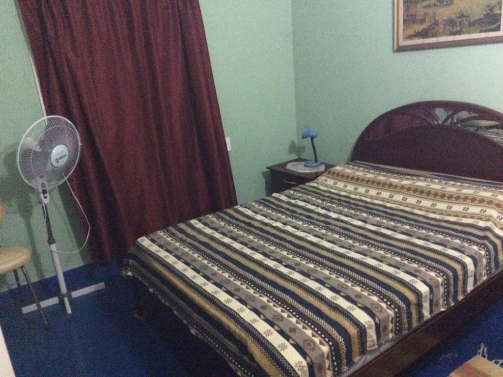 um quarto com uma cama, uma ventoinha e uma janela em Casa Cami seña para confirmar reserva em Piriápolis