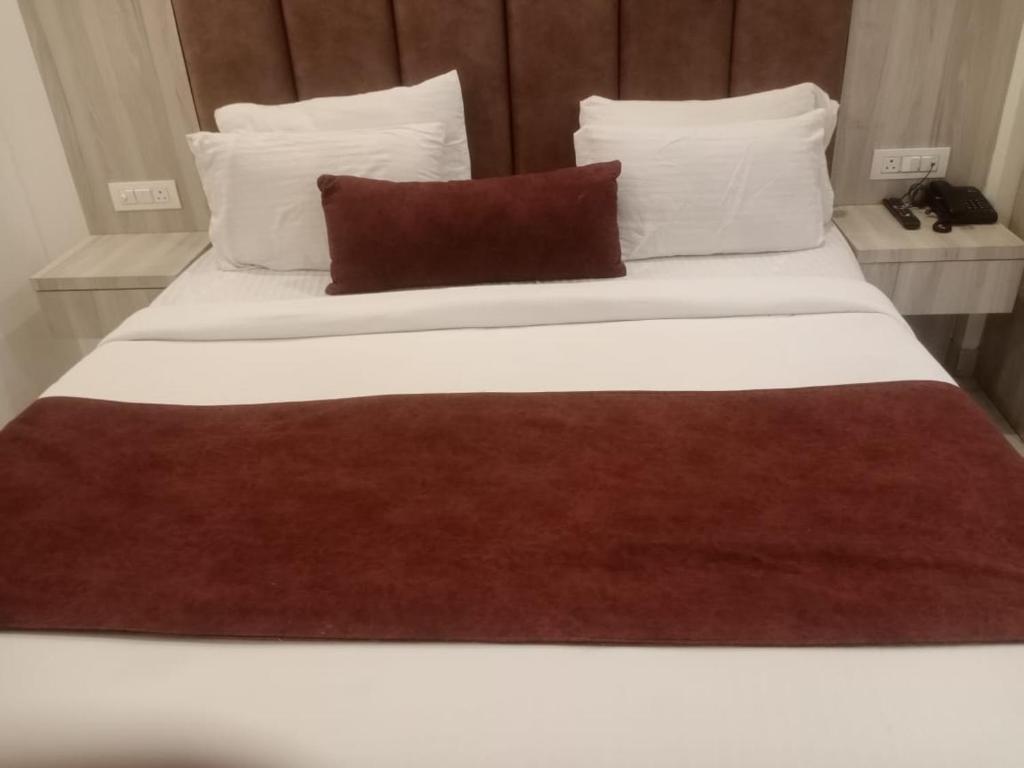a large white bed with a red blanket on it at Hotel The Best IGI Delhi in Kānpur
