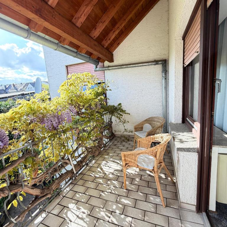 a patio with a table and chairs on a balcony at Winzerhaus St Joseph in Piesport