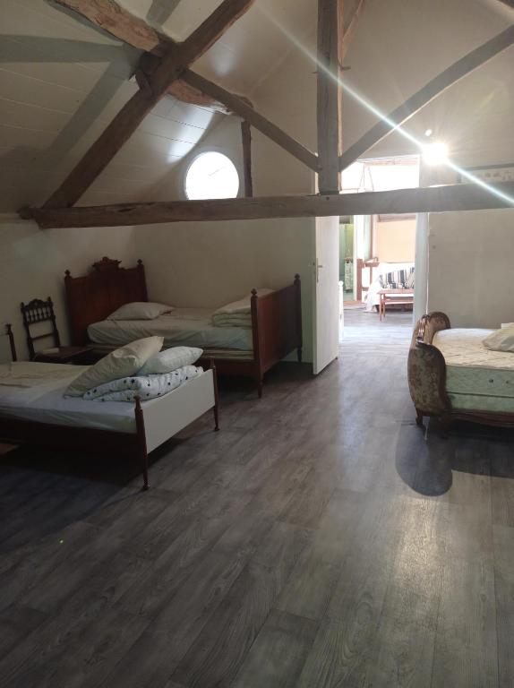 a room with three beds and a wooden floor at Gîte rustique en Morvan in Brassy