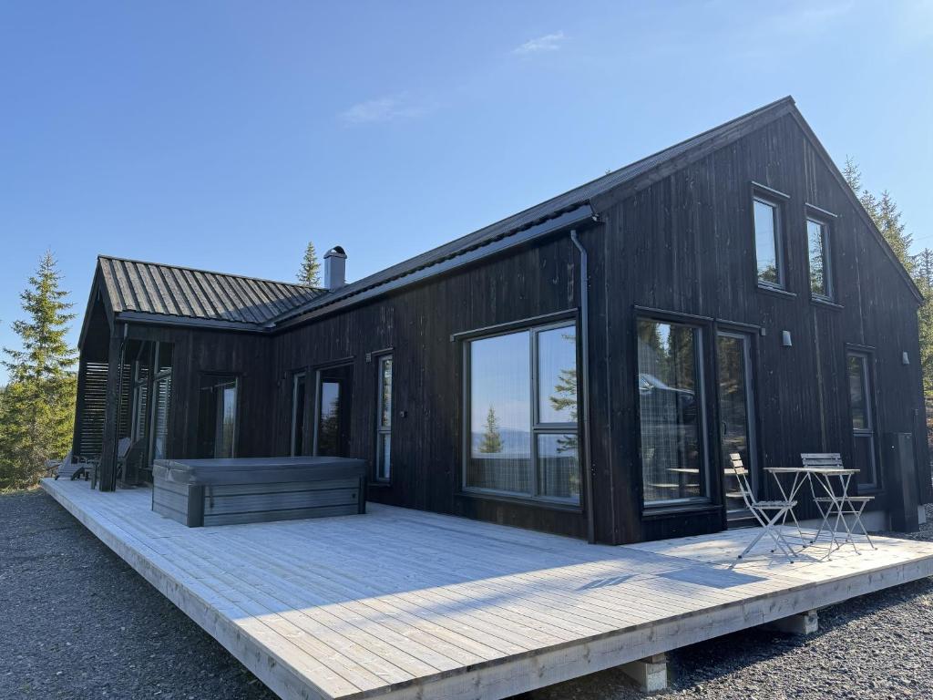a black modular house with a wooden deck at Hafjell Luxury Lodge in Øyer
