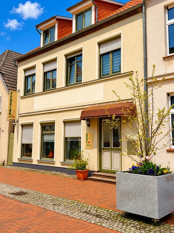 a building on a brick street with a potted plant at Pension am Bernsteinmuseum - Doppelzimmer in Ribnitz-Damgarten