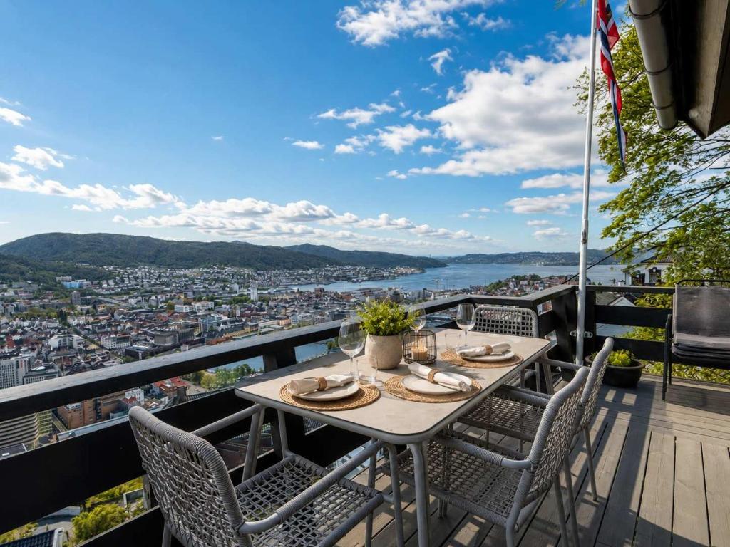 a table and chairs on a balcony with a view at Skyline View - Nordic Villa Above Bergen in Bergen