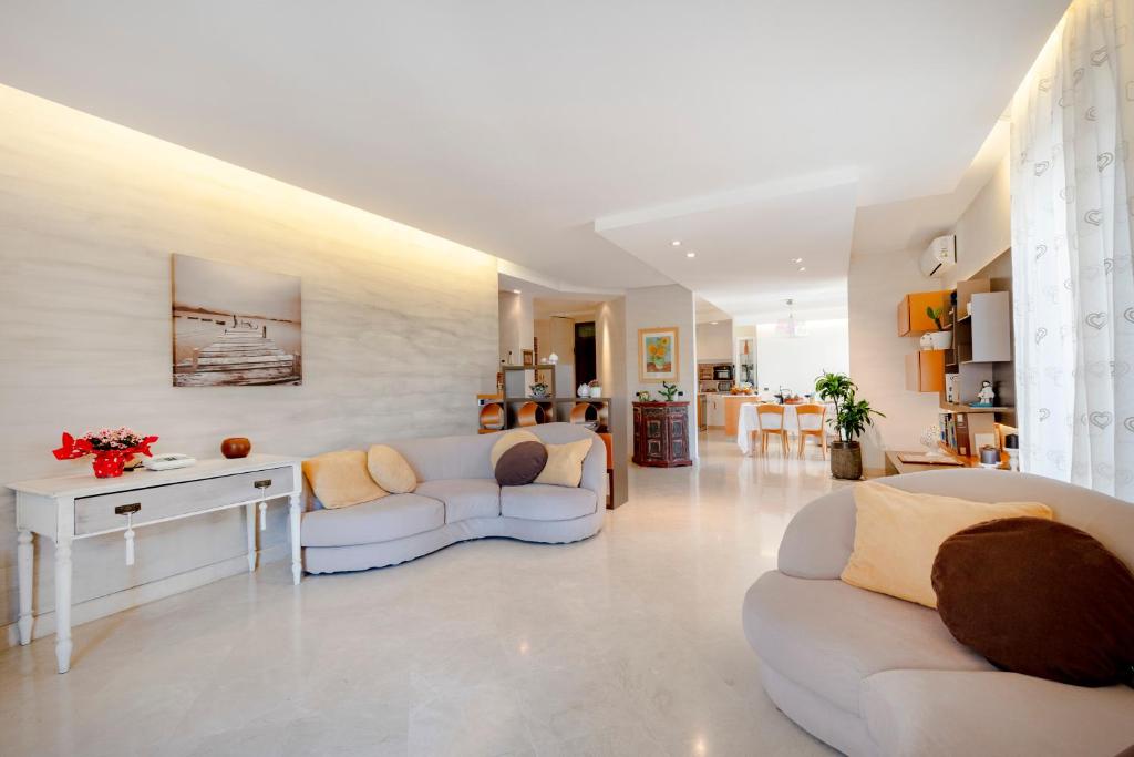 a living room with two white couches and a table at Damè in Conversano