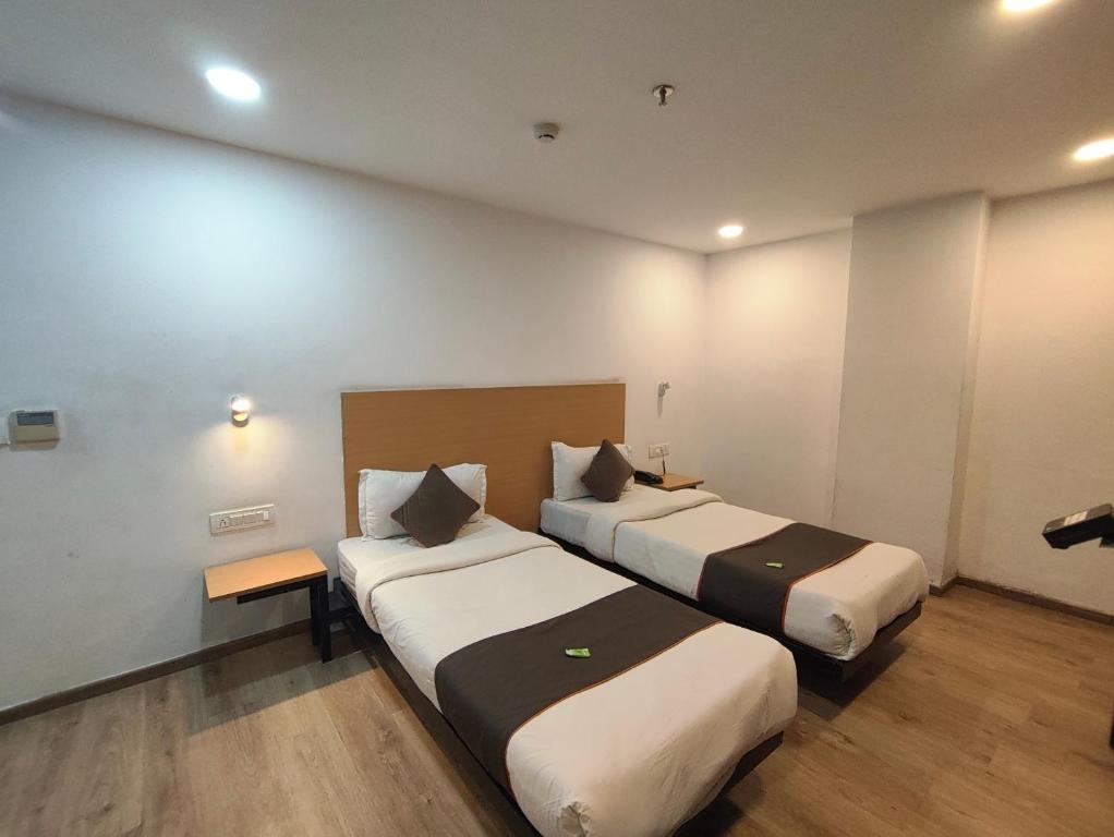 a hotel room with two beds in a room at GH Brother Eureka in Guwahati